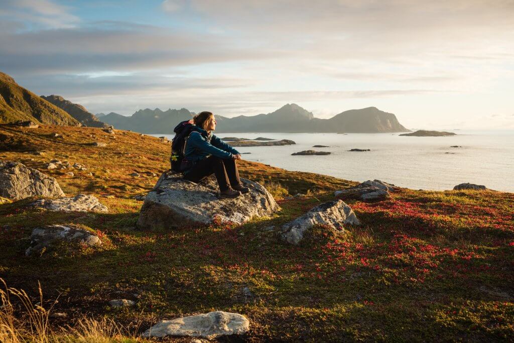 Frau mit Rucksack geniesst die norwegische Landschaft